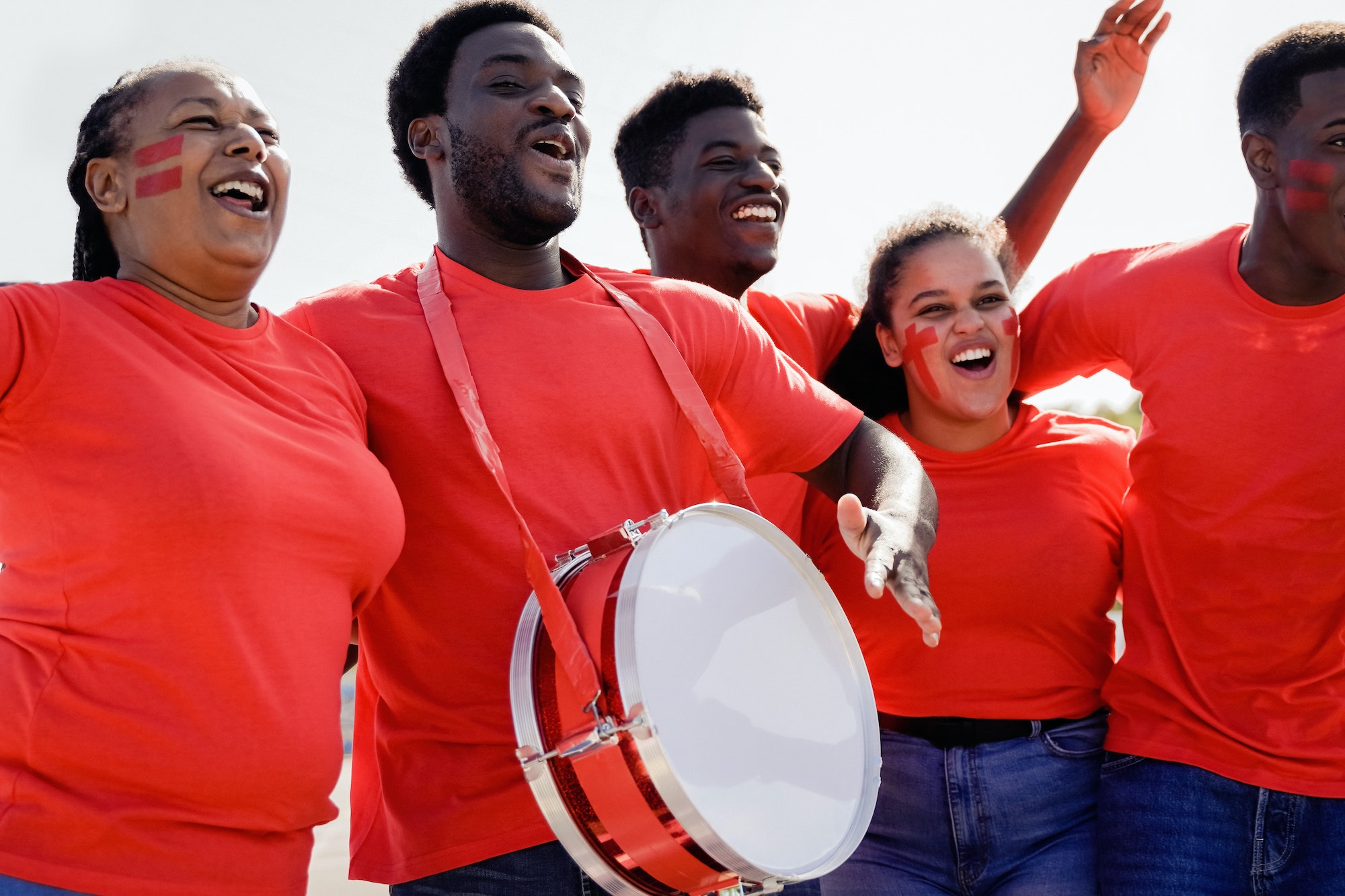 African red sport football fans celebrating team victory in soccer championship game at stadium crow